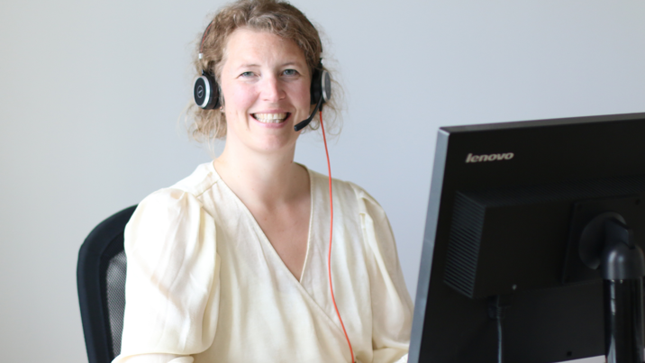 Kundrådgivare med headset sitter vid skrivbordet